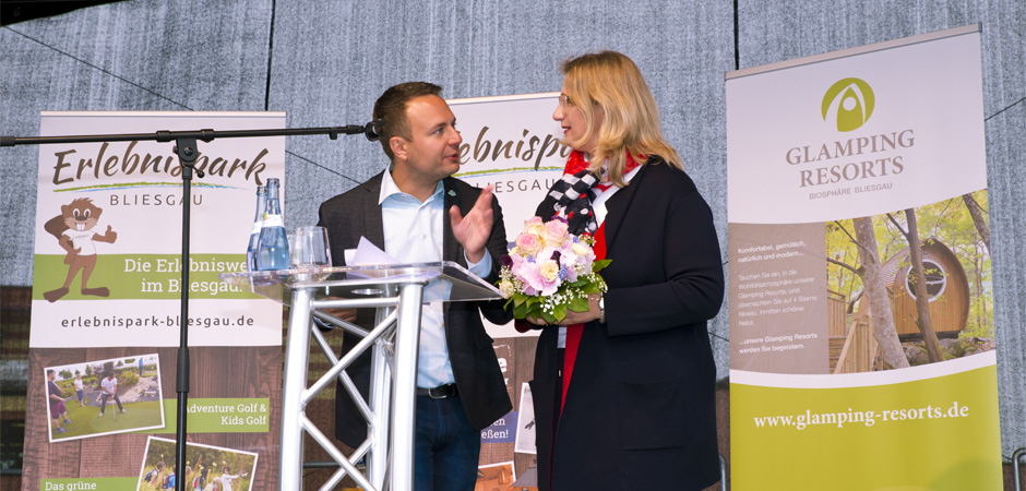 Sven Becker, WYRD Gastro GmbH, auf der Bühne mit Anke Rehlinger bei der Eröffnungsfeier des Glamping Resorts